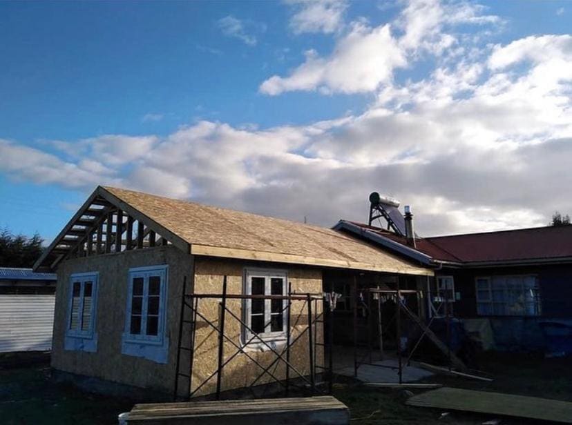 Ampliación en construcción con tabiquería de madera y placas OSB bajo un cielo despejado